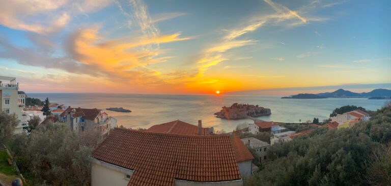 a beautiful sunset over a small town by the ocean