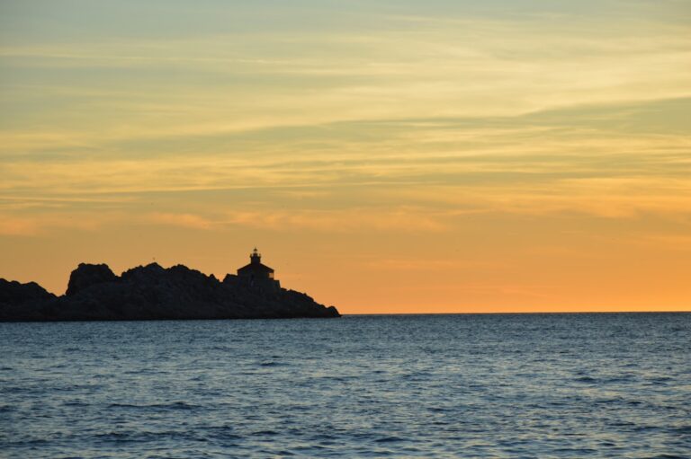 Secrets of Local Life in Dubrovnik โ Travel Guide to Dubrovnik 34 Explore the serene beauty of Dubrovnik with this captivating sunset scene featuring a distant lighthouse against the backdrop of the shimmering sea. Perfect for conveying tranquility and coastal charm.