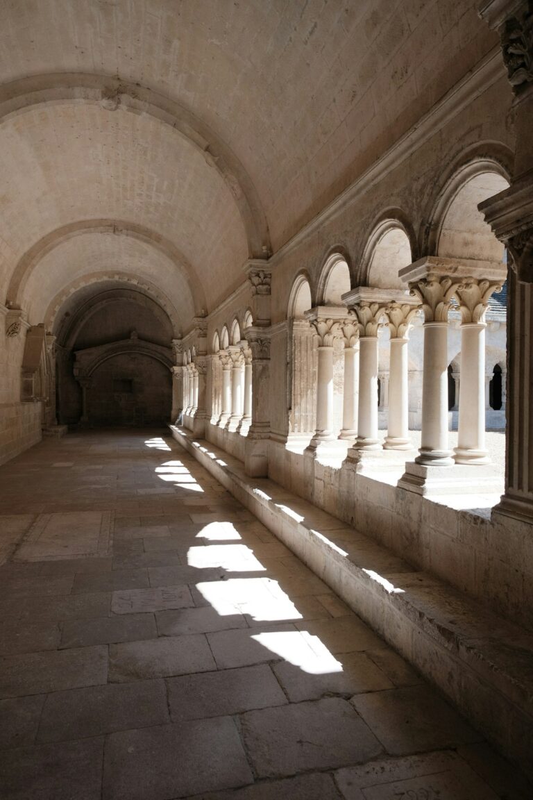 A long hallway with stone pillars and arches